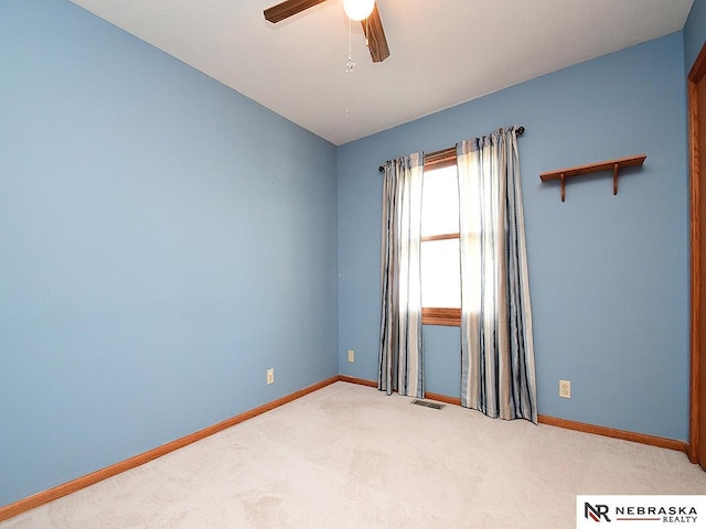 empty room with carpet floors, baseboards, and a ceiling fan