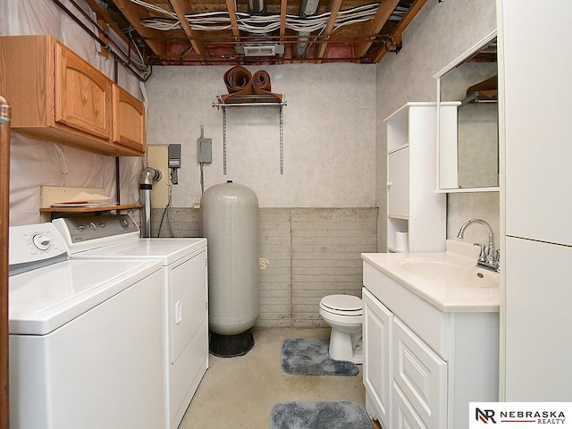 clothes washing area featuring laundry area, separate washer and dryer, and a sink