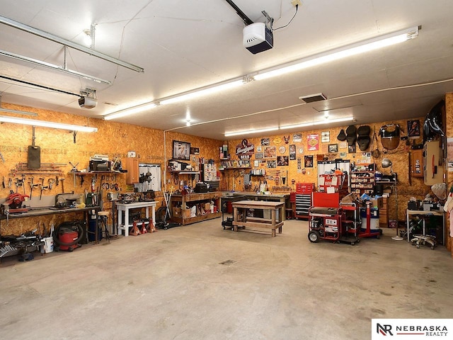 garage with a workshop area and a garage door opener