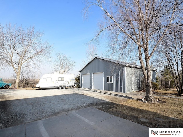 exterior space with a garage and an outbuilding