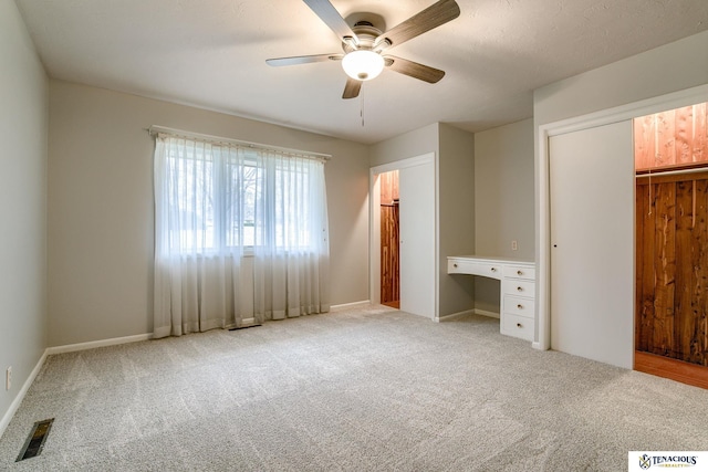 unfurnished bedroom featuring carpet, a closet, visible vents, and ceiling fan