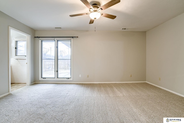 spare room featuring ceiling fan, carpet flooring, visible vents, and baseboards