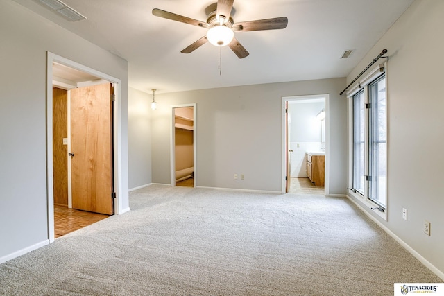 unfurnished bedroom featuring carpet floors, a spacious closet, and visible vents