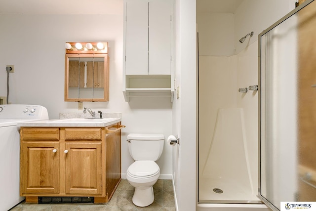 full bathroom featuring washer / clothes dryer, toilet, a shower stall, vanity, and tile patterned floors