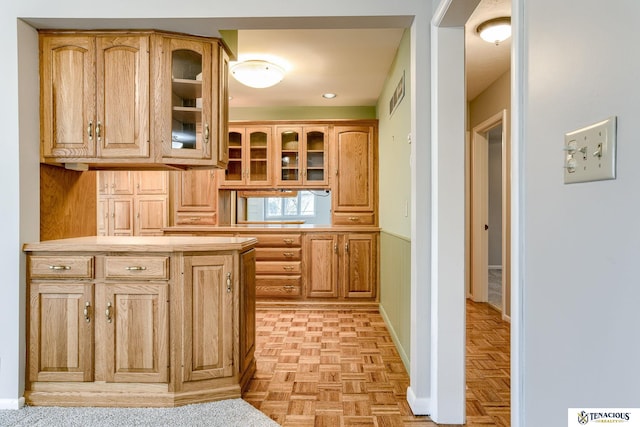 kitchen featuring visible vents, light countertops, and glass insert cabinets