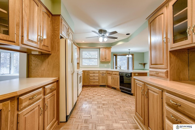 kitchen featuring a peninsula, white appliances, a ceiling fan, light countertops, and glass insert cabinets