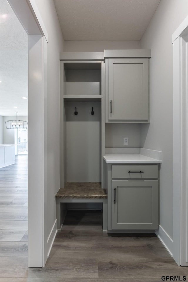 mudroom with wood finished floors and baseboards