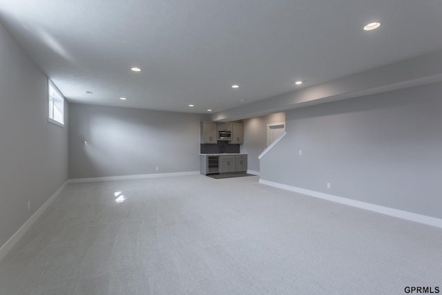 below grade area featuring baseboards, light colored carpet, and recessed lighting