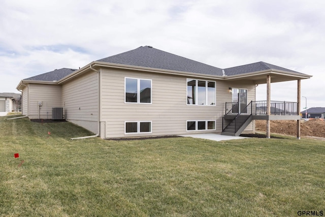 back of house with stairs, a yard, a shingled roof, and cooling unit