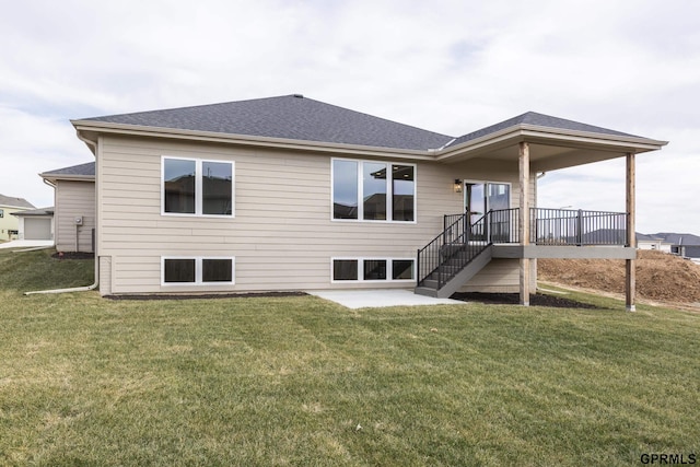 back of house featuring stairs, a patio, a shingled roof, and a lawn