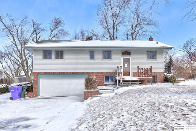 raised ranch featuring brick siding and an attached garage