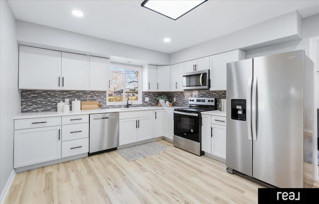 kitchen featuring white cabinets, appliances with stainless steel finishes, and light countertops