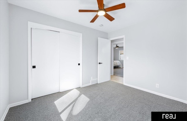 unfurnished bedroom with a ceiling fan, a closet, baseboards, and carpet flooring