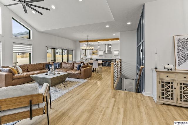 living room featuring ceiling fan with notable chandelier, recessed lighting, a wealth of natural light, and light wood-style floors