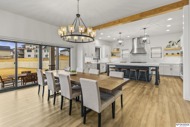 dining area featuring a notable chandelier, light wood-style flooring, beam ceiling, and recessed lighting