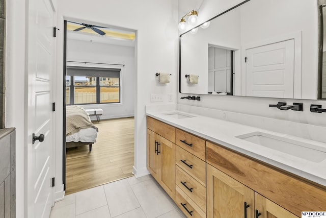 ensuite bathroom with double vanity, ensuite bath, a sink, and tile patterned floors