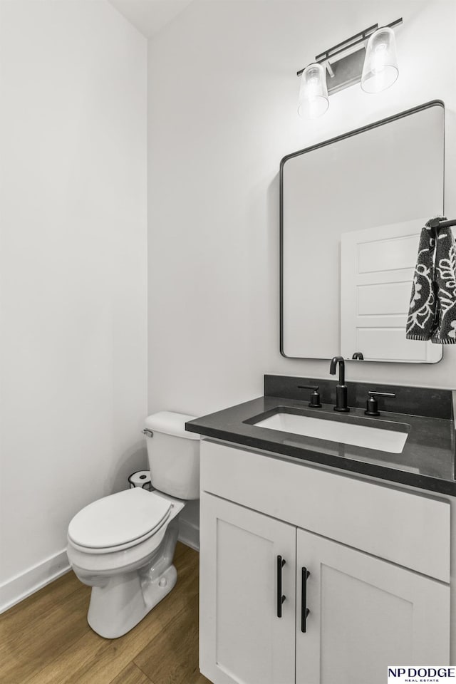 bathroom with vanity, wood finished floors, toilet, and baseboards