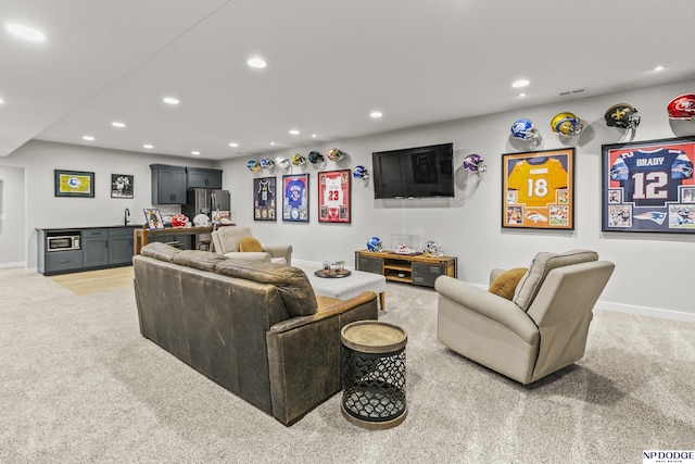 living room with indoor wet bar, recessed lighting, and light colored carpet