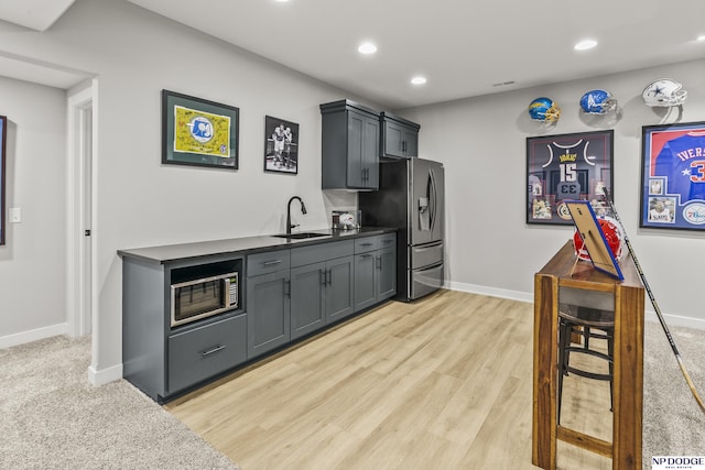 kitchen with baseboards, appliances with stainless steel finishes, a sink, and recessed lighting