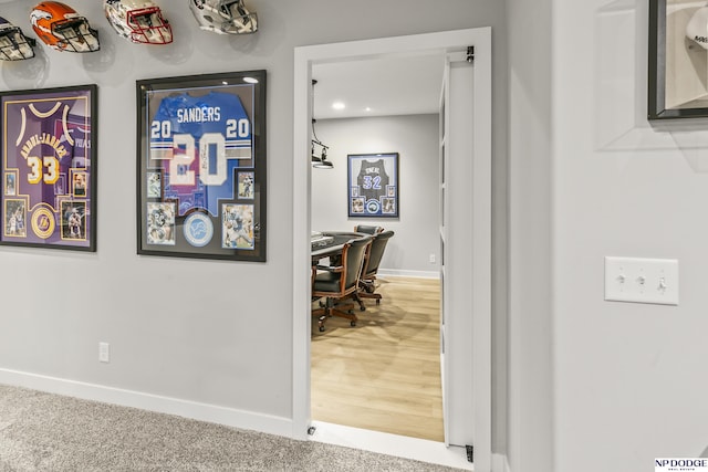 hallway with carpet flooring and baseboards