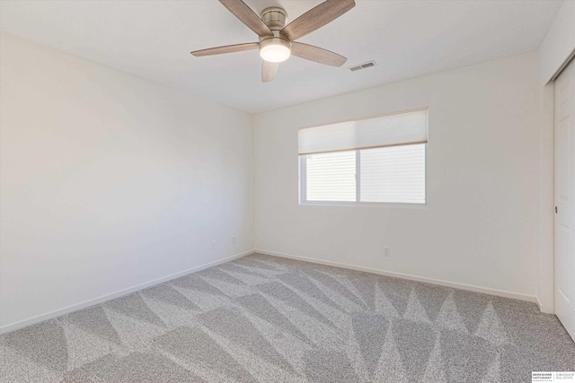 spare room featuring baseboards, visible vents, a ceiling fan, and light colored carpet