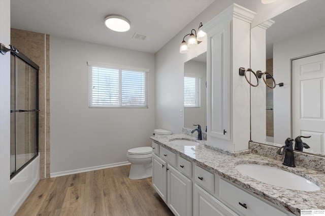 bathroom featuring visible vents, a sink, toilet, and wood finished floors