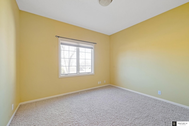 unfurnished room featuring carpet floors, visible vents, and baseboards