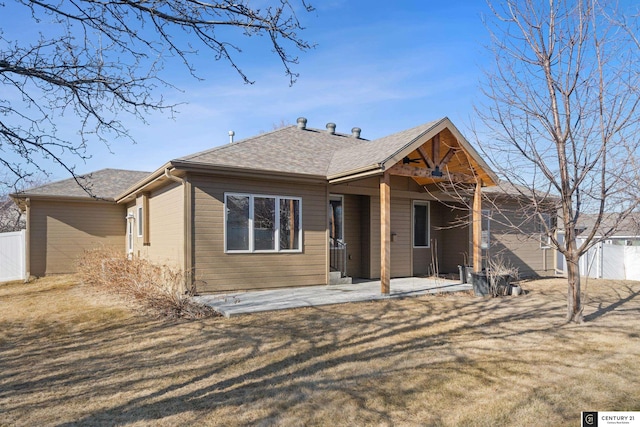 view of front of property featuring a patio area, a shingled roof, and fence