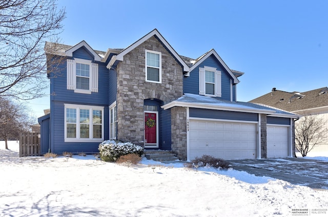 view of front of home with a garage, stone siding, and fence