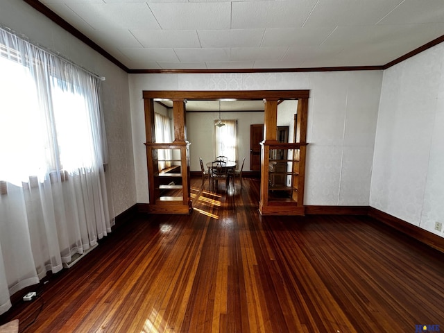 spare room with baseboards, hardwood / wood-style floors, and crown molding