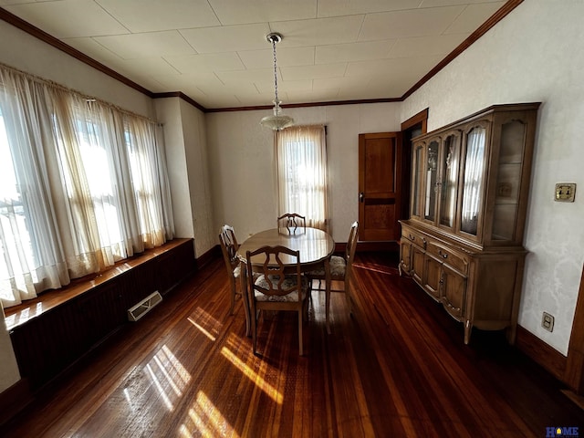 dining area with ornamental molding, dark wood finished floors, visible vents, and baseboards