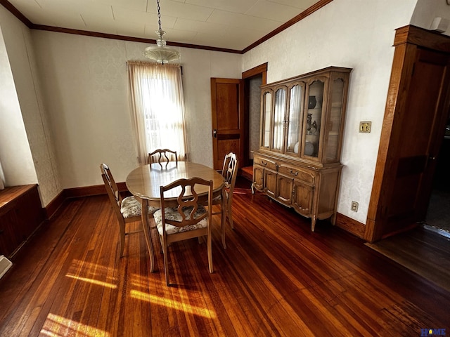 dining space featuring dark wood-style flooring, crown molding, and baseboards