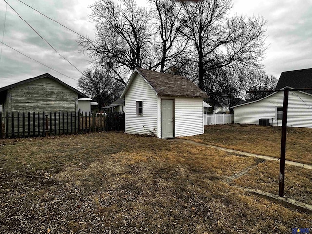 exterior space with an outbuilding, central AC, and fence