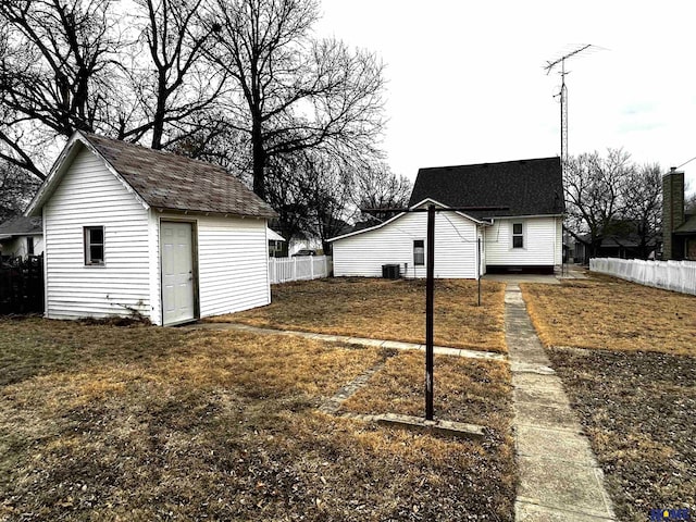 view of yard featuring fence, cooling unit, and an outbuilding