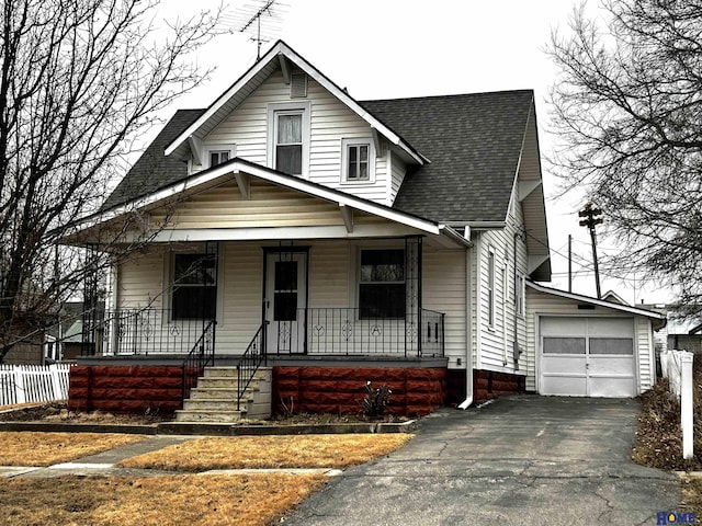 bungalow featuring an outbuilding, a porch, a garage, a shingled roof, and fence