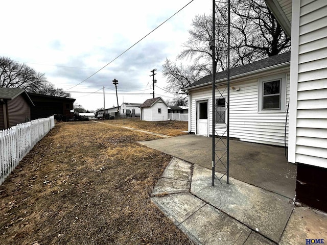 view of yard featuring concrete driveway and fence