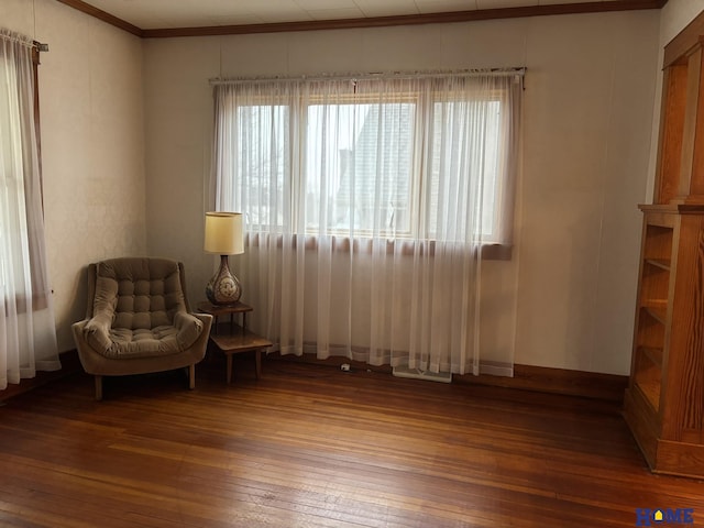 living area with hardwood / wood-style flooring, baseboards, and crown molding