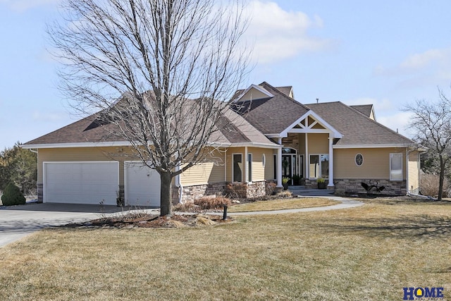 craftsman inspired home featuring a shingled roof, a front yard, a garage, stone siding, and driveway