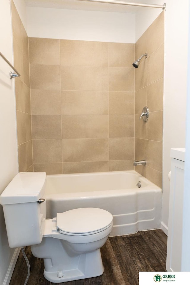 bathroom with toilet, baseboards, wood finished floors, and bathing tub / shower combination