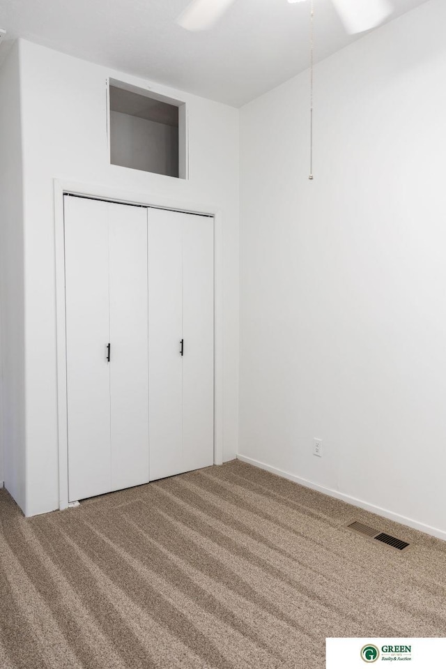 unfurnished bedroom with a closet, carpet flooring, and visible vents