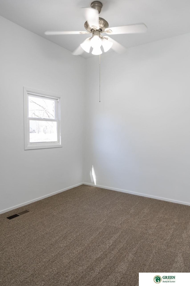 carpeted spare room with visible vents, ceiling fan, and baseboards