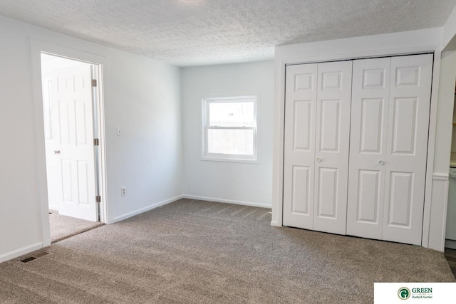 unfurnished bedroom featuring a textured ceiling, carpet, and baseboards