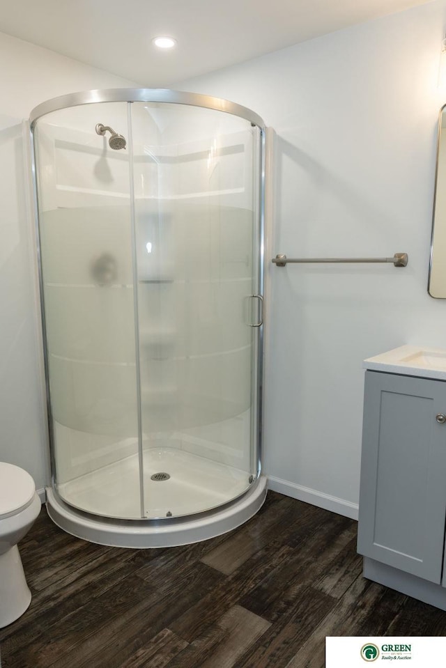 full bath with toilet, recessed lighting, wood finished floors, vanity, and a shower stall