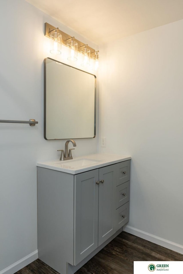 bathroom with baseboards, wood finished floors, and vanity