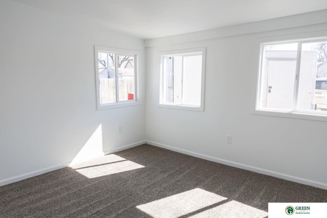 carpeted spare room featuring baseboards