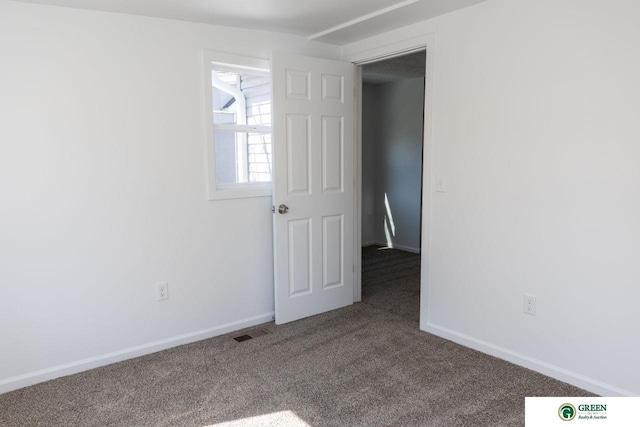 carpeted spare room with visible vents and baseboards