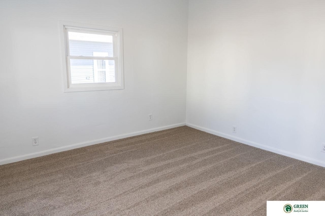 spare room featuring carpet flooring and baseboards