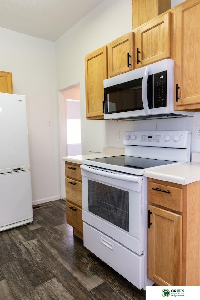 kitchen with light countertops, backsplash, dark wood-type flooring, white appliances, and baseboards