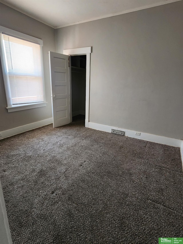 unfurnished bedroom with ornamental molding, visible vents, carpet floors, and baseboards