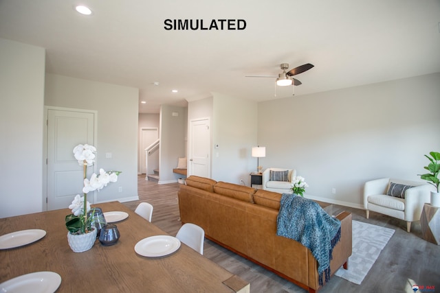 living room featuring stairs, baseboards, wood finished floors, and recessed lighting